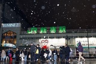 　雪が降るＪＲ新宿駅前を歩く人たち＝２日夜