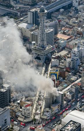 　大阪市浪速区の火災現場。奥は通天閣＝９日午前１１時１７分（共同通信社ヘリから）