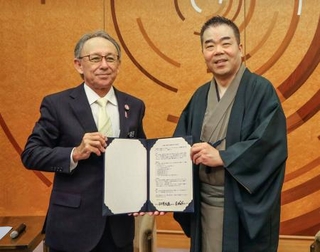 　協定書を手にする滋賀県の三日月大造知事（右）と沖縄県の玉城デニー知事＝９日午前、大津市