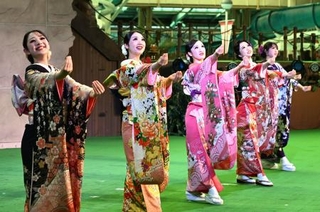 　福島県いわき市の温泉施設スパリゾートハワイアンズで、振り袖姿でダンスを披露する（左から）ＭＯＭＯＫＡさん、ＭＩＭＩさんら２０歳になるフラガール＝１０日午前