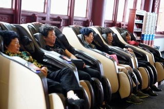 　マッサージチェアで休憩する人たち＝２０２４年４月、中国浙江省東陽市横店鎮（共同）