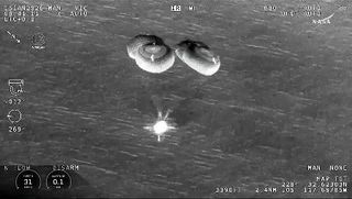 　米カリフォルニア州沖の海面に着水する、油井亀美也飛行士ら搭乗の宇宙船クルードラゴン＝１５日（ＮＡＳＡの中継から）