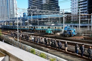 　新橋-浜松町間で停車したＪＲ京浜東北線の車両から降りて線路を歩く乗客＝１６日午前９時５６分、東京都港区