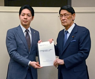　北海道の鈴木直道知事（左）から要望書を受け取る与党プロジェクトチーム共同座長の渡海紀三朗衆院議員＝１７日午後、札幌市