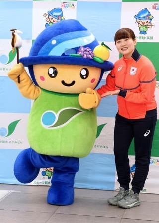　壮行会で相模原市のキャラクターと記念写真に納まるカーリング女子日本代表の小谷優奈＝１９日、相模原市役所