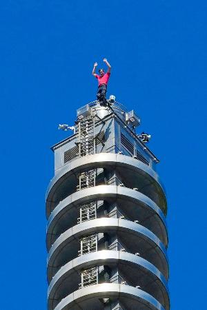 　「台北１０１」を登り切って手を振るオノルドさん＝２５日、台北（中央通信社＝共同）