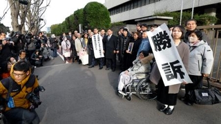 　脱北者ら４人が北朝鮮政府に損害賠償を求めた訴訟の差し戻し審判決で勝訴し、写真に納まる原告ら＝２６日午後、東京地裁