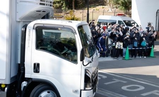 　双子のジャイアントパンダ、シャオシャオとレイレイを乗せて上野動物園を出発するトラックを見送る人たち＝２７日午後、東京都台東区