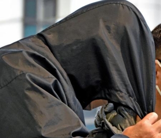 　鹿児島県・奄美大島から移送され、羽田空港に到着した小畑寛昭容疑者＝２７日午後４時５９分ごろ