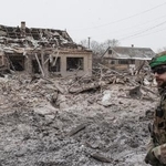 　破壊された家の前を歩くウクライナ兵＝２０２５年１２月３１日、ウクライナ東部ドネツク州（ゲッティ＝共同）