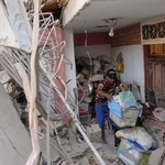 　４日、ベネズエラ首都カラカス近郊で、米国の攻撃で損壊したアパートを片付ける住民（ＡＰ＝共同）