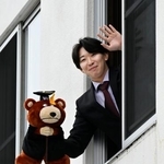 　楽天の寮に入り、自室から手を振る伊藤樹＝５日、仙台市