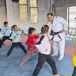 　空手教室で練習する少女たち。奥で教えるのはハッサン・ライさん＝２０２５年１２月、ガザ市（共同）