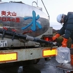 　断水が起きている鳥取県南部町で、給水車から水をくむ町職員＝７日午前７時２１分