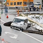 　強い地震があった青森県東北町の陥没した道路と車両＝２０２５年１２月９日