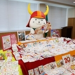　届いた年賀状の山を前に羽子板を持って喜ぶ「ひこにゃん」＝７日午後、滋賀県彦根市役所