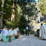 　「那智の滝」（右奥）の前で営まれた、熊野那智大社の「牛王神璽祭」＝８日午前、和歌山県那智勝浦町
