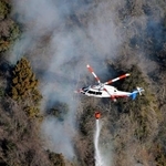 　延焼が続く扇山で放水するヘリコプター＝９日午前９時３分、山梨県上野原市（共同通信社ヘリから）