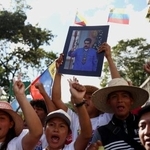 　８日、ベネズエラ・カラカスでマドゥロ大統領の写真を掲げ、解放を求める支持者ら（ロイター＝共同）