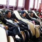 　マッサージチェアで休憩する人たち＝２０２４年４月、中国浙江省東陽市横店鎮（共同）