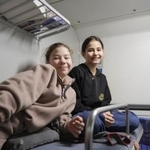 　「不屈の車両」の寝台車の２段ベッドで過ごすベロニカさん（右）ら＝１１日、キーウ近郊（共同）