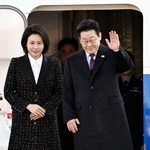 　訪日のため大統領専用機に乗り込む韓国の李在明大統領（右）夫妻＝１３日、ソウル郊外（共同）