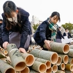 　「１・１７のつどい」が開かれる会場で竹灯籠を並べる高校生＝１５日午後、神戸市中央区の東遊園地