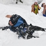 　奇祭「むこ投げ」で雪の斜面に投げ落とされ転がる俵山舜平さん＝１５日午後、新潟県十日町市