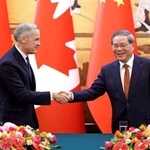 　カナダのカーニー首相（左）と握手する中国の李強首相＝１５日、北京（ロイター＝共同）