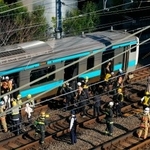 　高輪ゲートウェイ-田町間で停車したＪＲ京浜東北線の車両から線路に降りる乗客＝１６日午前９時７分、東京都港区