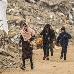 　１８日、ガザ北部ガザ市で、がれきの中を歩くパレスチナ人（ゲッティ＝共同）