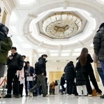 　中国国家統計局のＧＤＰ速報値に関する資料を受け取るために並ぶ報道関係者ら＝１９日、北京（共同）