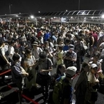 　大阪・関西万博会場にアクセスする地下鉄がトラブルで運転を見合わせ、会場のゲート前で並ぶ人たち＝２０２５年８月、大阪市此花区の夢洲