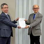 　気象庁の野村竜一長官（左）に報告書を手渡す京都大防災研究所の矢守克也教授＝２０日午後、気象庁