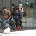 　雪が降る新潟県長岡市内を歩く人たち＝２０日午後