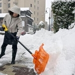 　雪かきをする人＝２３日午前、金沢市