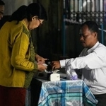 　ミャンマー総選挙の第３回投票で投票を終えてインクに指を浸す有権者＝２５日、ヤンゴン（ＡＰ＝共同）