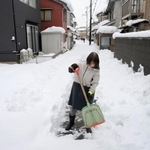 　自宅前で雪かきをする女性＝２５日午後、福井市