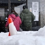 　雪が積もる中、福井県知事選の投票所に向かう人たち＝２５日午後、福井市
