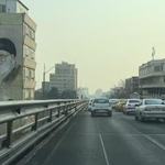 　イラン革命の指導者、故ホメイニ師（左）と最高指導者ハメネイ師の絵が描かれた建物近くを走る車＝２５日、テヘラン（ＡＰ＝共同）