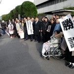 　脱北者ら４人が北朝鮮政府に損害賠償を求めた訴訟の差し戻し審判決で勝訴し、写真に納まる原告ら＝２６日午後、東京地裁