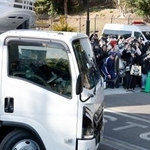 　双子のジャイアントパンダ、シャオシャオとレイレイを乗せて上野動物園を出発するトラックを見送る人たち＝２７日午後、東京都台東区