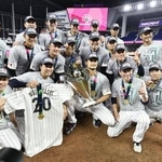 　２０２３年３月、ＷＢＣで優勝し、トロフィーを手にしたダルビッシュを中心に記念写真に納まる投手陣ら＝マイアミ（共同）