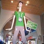 　愛知・名古屋アジアパラ大会でボランティアが着用するユニホームの特別サイズを着た「ナナちゃん」と記念写真に納まる関係者＝２８日午後、名古屋市