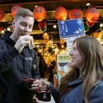 　神奈川県鎌倉市の商店街で日本酒を楽しむスウェーデンからの訪日客＝２５年１２月