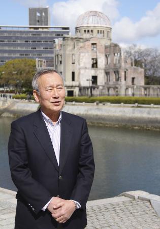 　原爆ドーム（後方右）と秋葉忠利・前広島市長＝２０２０年２月、広島市の平和記念公園