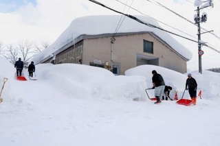 　建物の周囲を除雪する人たち＝２日午後、青森市