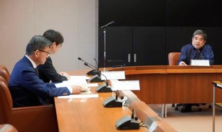 　米軍が嘉手納基地でパラシュート降下訓練を実施したことについて、防衛省沖縄防衛局の村井勝局長（左手前）らに抗議する沖縄県の池田竹州副知事（右）＝４日午後、沖縄県庁