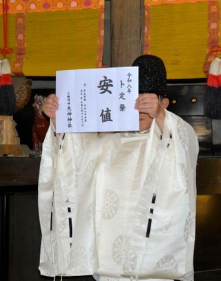 　奈良県桜井市の大神神社の「卜定祭」で「安値」を知らせる神職＝５日午後