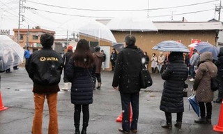 　雪が降る中、候補者の街頭演説に耳を傾ける人たち＝７日午後、茨城県行方市